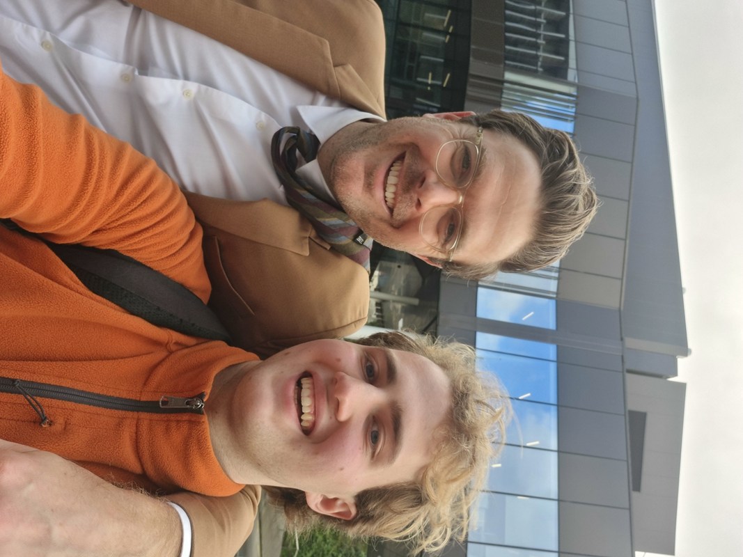 Zade Viggers in a orange fleece gets cozy with Guy Williams in his signature light brown suit